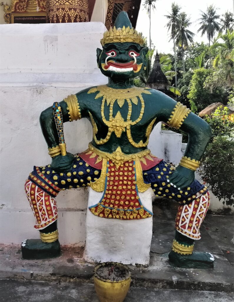 A wildly designed depiction of an almost-human green being by the temple with lush greenery. In the post: Infinite Earth Art: Temples of Luang Prabang.