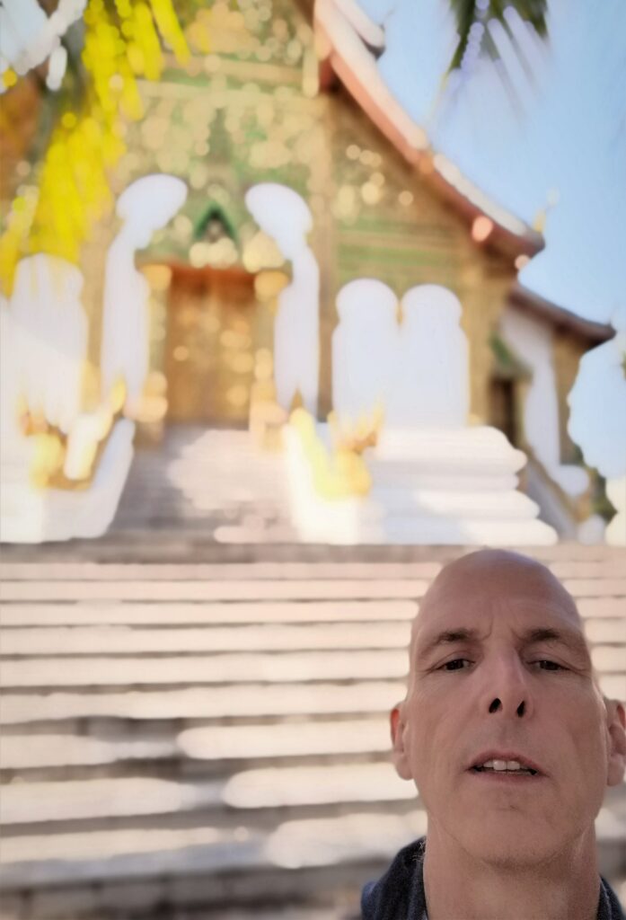 Selfie in front of several steps and a glittering façade. 