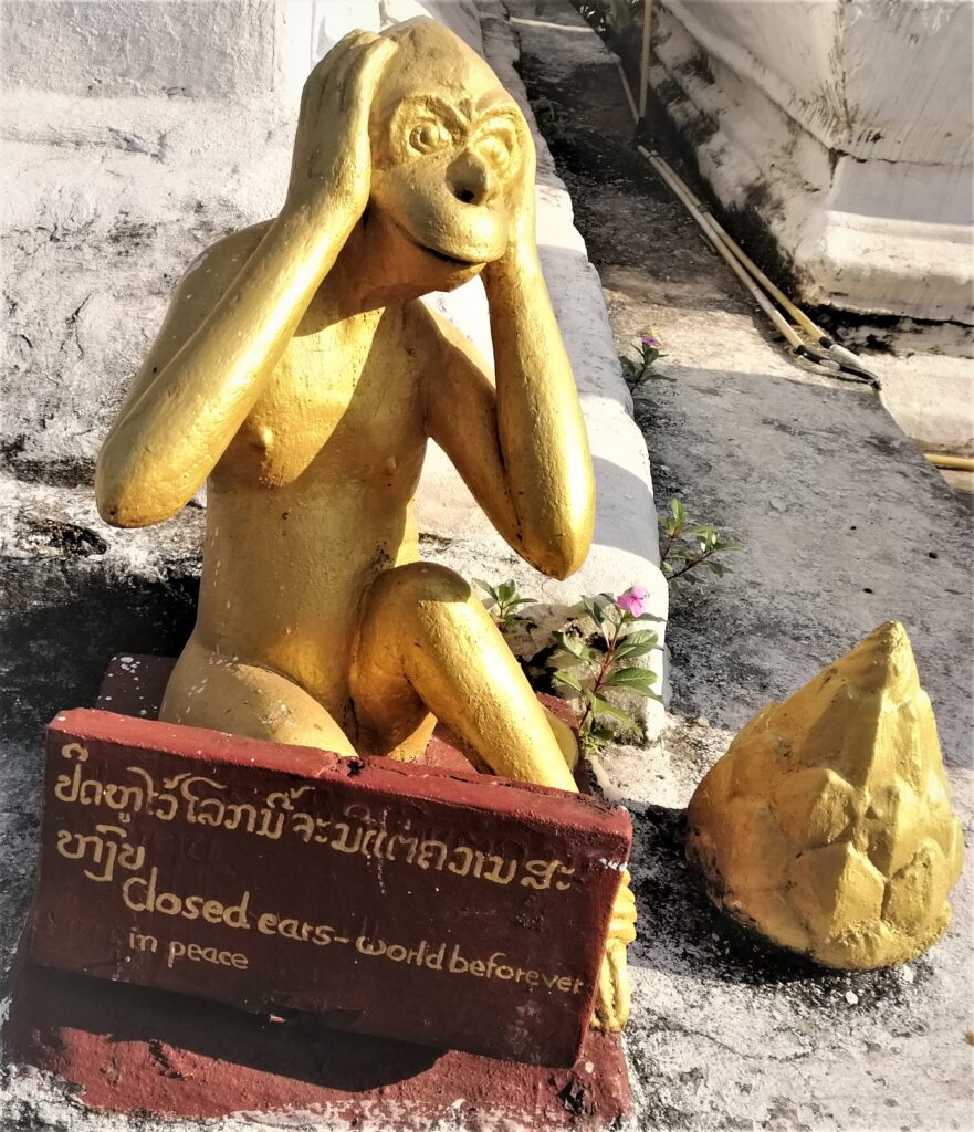 Fed up ape depiction with a sign 'closed ears world be forever in peace'. In the post: Infinite Earth Art: Temples of Luang Prabang.