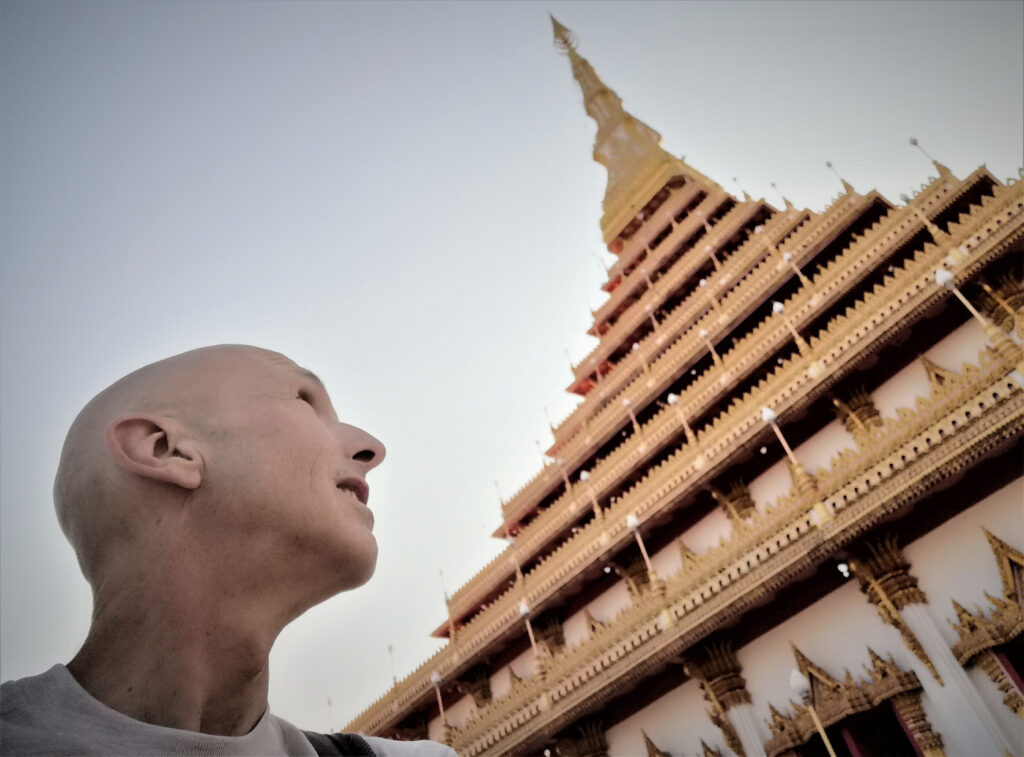 Me looking up at sunning, pagoda and pyramid style Buddhist architecture. In post: Khon Kaen: A City of Unknown Wonders.