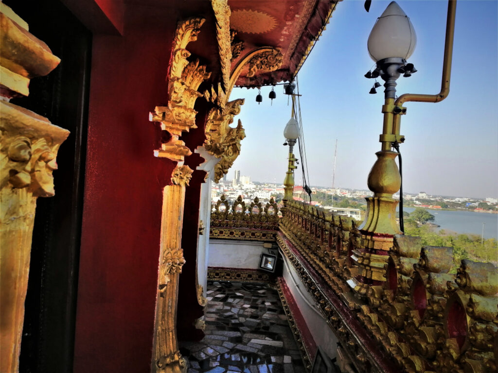 Upon exotic Buddhist style architecture with views of a pond and downtown in the distance. In post: Khon Kaen: A City of Unknown Wonders.