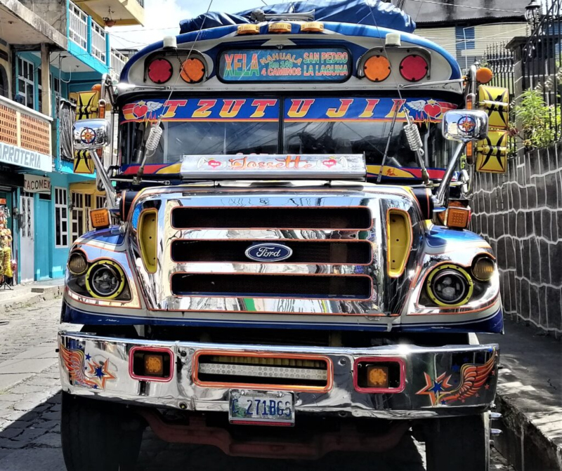 A colorfully refurbished US school bus sits on a road in San Pedro la Laguna, Guatemala. From the post: Former US School Buses: The Pulse of a Nation