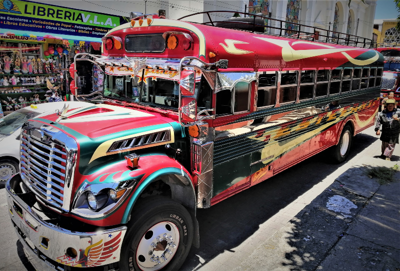 A flashy-looking, refurbished US hand-me-down bus sits parked beside the plaza in Sololá, Guatemala.