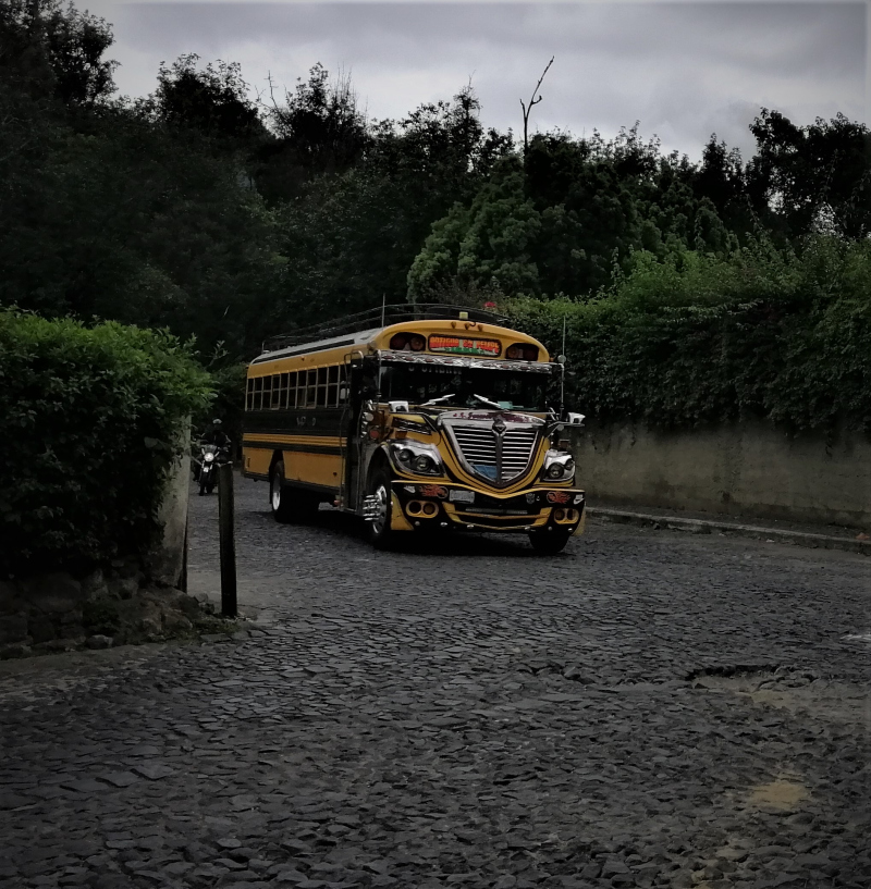 A renovated US school bus rolls along vintage Spanish cobblestones in Antigua, Guatemala.  From the post: Refurbished Former US School Buses: The Pulse of a Nation