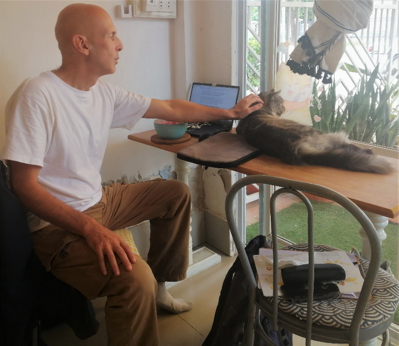 Petting a cat that jumped up on the table at Le Cattitude Café in Vientiane. 